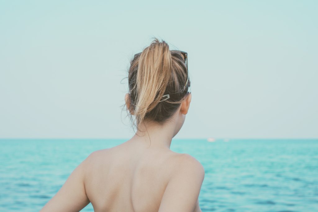 海を前に佇むポニーテールの女性