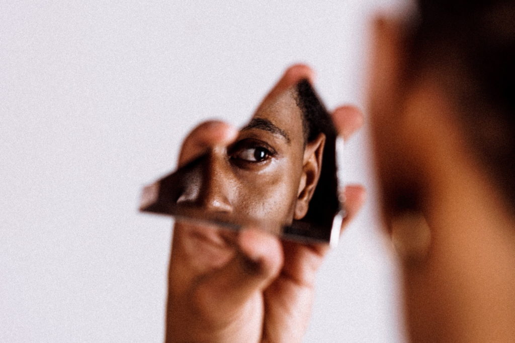 鏡の破片に映る黒人男性の顔