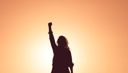 拳を突き上げる女性のシルエット