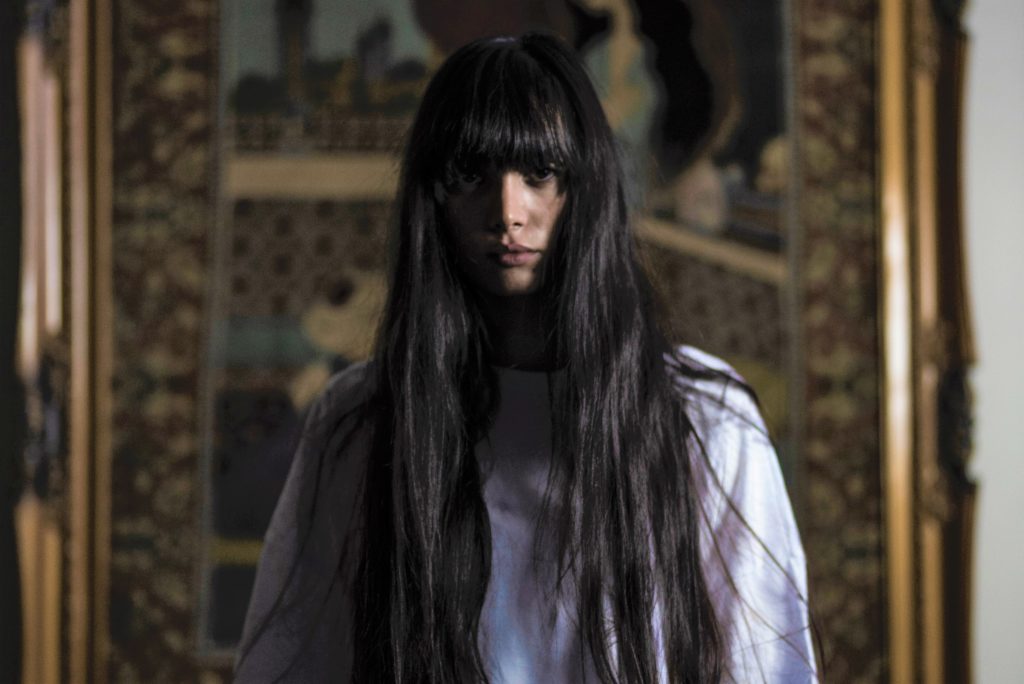 まっすぐレンズを見つめる黒髪ロングヘアの女性
